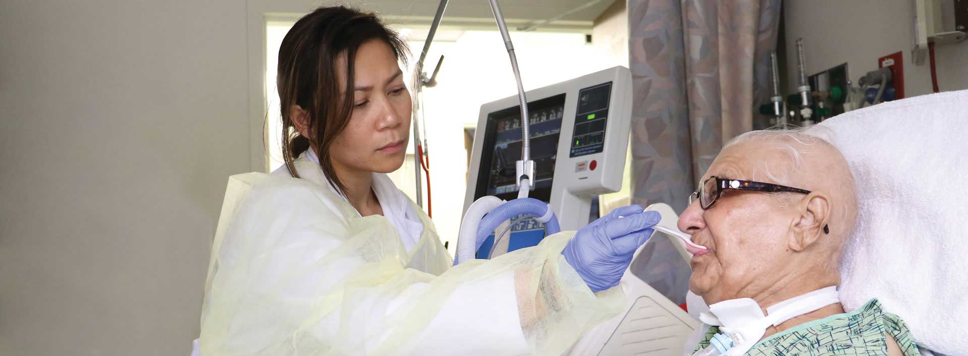 Clinician feeding a tracheostomized and ventilated patient Clinician feeding a tracheostomized and ventilated patient